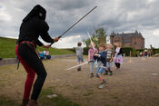 Kinderen doen mee aan een gevecht op het Muiderslot van 
